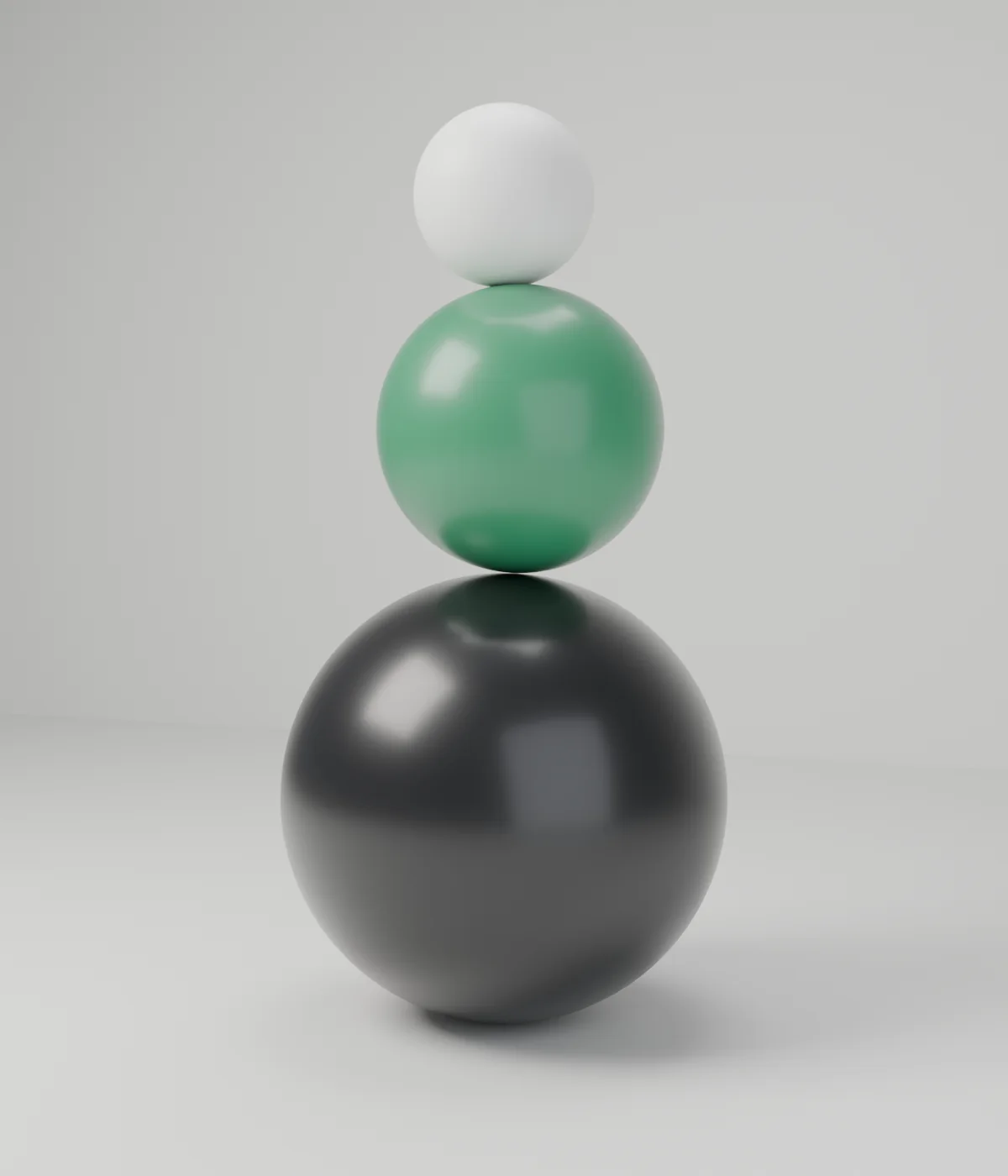 Black, green and white spheres balanced on top of each other